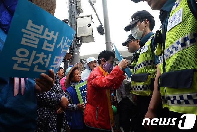 사드배치에 반발하는 성주·김천 주민들이 8일 오후 서울 광화문 미대사관 앞에서 열린 기자회견에서 트럼프 미 대통령에게 전달할 참외를 들고 경찰과 대치하고 있다. 2017.5.8/뉴스1 © News1 오대일 기자