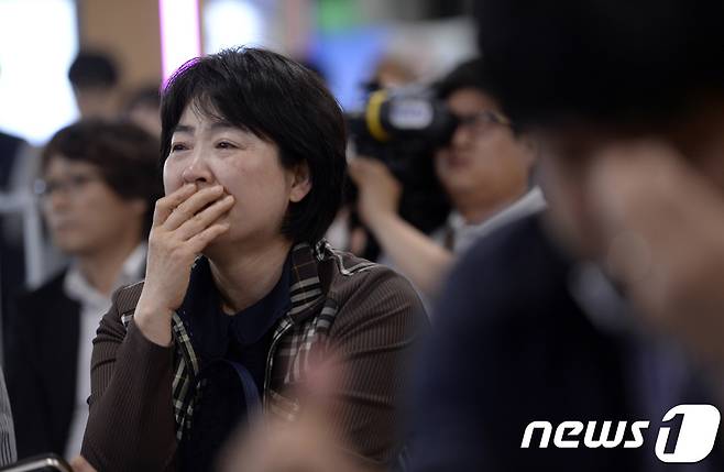 제19대 대통령 선거일인 9일 오후 서울역에서 방송3사 출구조사 결과를 지켜보던 한 유권자가 눈물을 흘리고 있다. 2017.5.9/뉴스1 © News1 안은나 기자