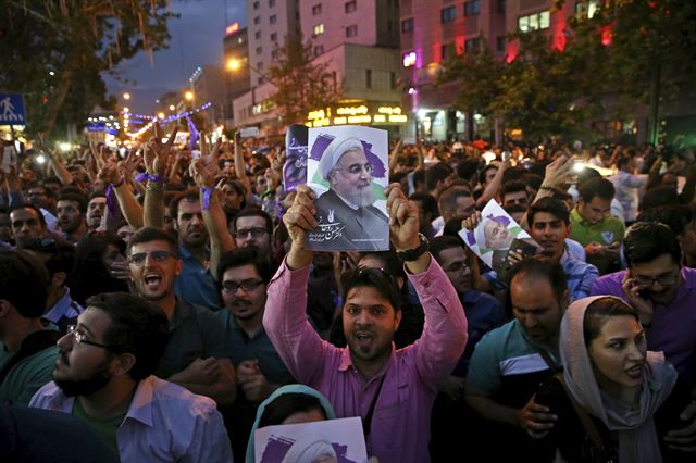 하산 로하니 대통령의 지지자들이 20일 밤 거리에서 손을 들어 환호하고 있다. 테헤란=AP 연합뉴스