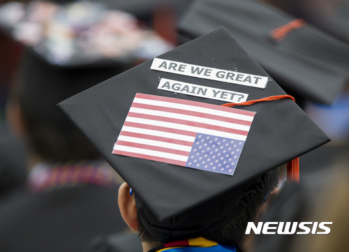 【사우스벤드 (미 인디애나주)= 스】 미 노터데임 대학교의 2017년 졸업식이 열린 21일(현지시간) 한 졸업생이 사각모 위에다 "우리 미국은 이미 다시 위대해졌는가?"라는 정치구호를 붙이고 항의에 나섰다.