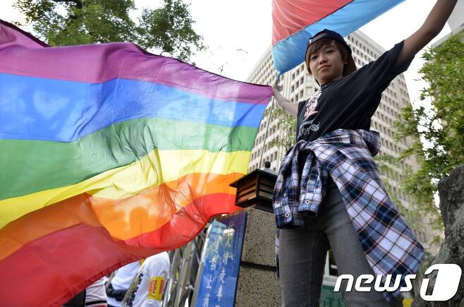 동성혼 허용을 지지하는 대만 시민이 타이베이 의회 밖에서 무지개 깃발을 들고 있다. © AFP=뉴스1