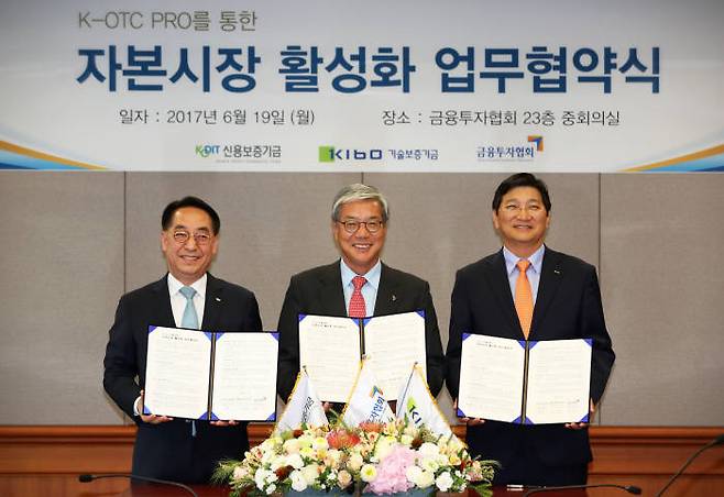 금융투자협회 및 신용보증기금, 기술보증기금 등 정책보증기관장들이 19일 서울 여의도 금융투자협회에서 K-OTC프로를 통한 자본시장 활성화 업무협약 체결 후 협약문을 들어 보이고 있다. 사진 왼쪽부터 신용보증기금 황록 이사장, 금융투자협회 황영기 회장, 기술보증기금 김규옥 이사장