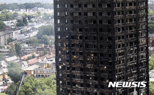 영국 런던 소방당국이 화재가 발생한 그렌펠 타워에서 지난 15일(현지시간) 점검 작업을 진행하고 있다. <런던=AP/뉴시스>