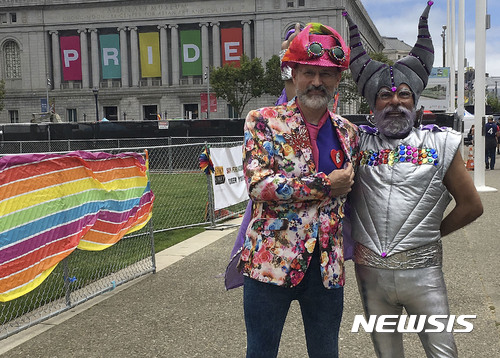 【샌프라시스코 = AP/뉴시스】 = 샌프란시스코에서 25일 열린 동성애 축제의 프라이드행진에 참가한 폴 브래들리(왼쪽)와 프랭크 레이에스가 포즈를 취하고 있다.   이들은 트럼프정부의 정책에 항의하기 위해 몇년 만에 처음으로 행진에 나왔다고 말했다.