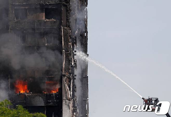 지난 14일(현지시간) 영국 런던 그렌펠타워에서 대형화재가 발생해 최소 79명이 사망했다. 사진은 당시 화재를 진압하는 소방관들의 모습. © AFP=뉴스1