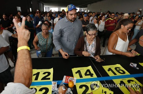 16일(현지시간) 베네수엘라 수도 카라카스에서 한 여성이 제헌의회 구성 찬반을 묻는 투표용지를 들고 있다. 베네수엘라 정부는 이달 30일 제헌의회 의원 선출을 위한 선거를 한다. 야권은 개헌에 반대하며 이날 독자적으로 개헌 찬반을 묻는 투표를 시행했다. 이번 선거는 법적 효력은 없지만, 개헌으로 위기를 돌파하려는 정부를 압박하는 수단으로 야권이 추진했다. [AFP=연합뉴스]