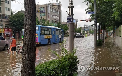 (서울=연합뉴스) 호우경보가 내려진 23일 오전 인천 부평구청역 인근 도로가 침수돼 시민들이 불편을 겪고 있다. 2017.7.23 [독자 제공=연합뉴스]      scoop@yna.co.kr