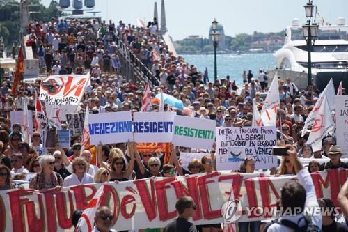 지난 7월 2일 이탈리아 베네치아에서 주민들이 '베네치아 주민들은 저항한다'라는 현수막을 들고 몰려드는 관광객으로 주민들의 이탈이 가속화하고 있는 상황에 항의하고 있다. [EPA=연합뉴스 자료사진]