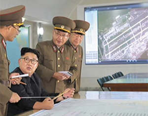 북한이 15일 보도한 김정은 북한 노동당 위원장의 전략군 사령부 시찰 장면. 스크린에 괌 앤더슨 미군 공군기지 위성 사진이 띄워져 있다. /조선중앙TV