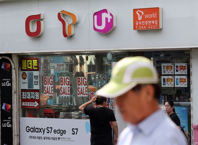 정부가 선택약정할인 신규 가입자에게 25% 할인율을 적용한다고 밝힌 지난 18일 오후 서울의 한 휴대폰 판매점 앞을 시민이 지나나가 있다. 연합뉴스