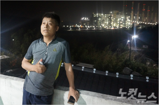 발전소가 내려다보이는 자신의 집 마당에서 인터뷰 중인 명덕마을 주민 이상열(51) 씨. (사진=김광일 기자)