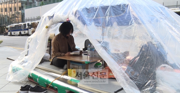 지난 30일 서울 종로구 수송동 옛 일본대사관 앞 인도에 마련된 비닐 천막 안에서 박지연씨가 독서를 하고 있다. 사진=문성호 기자 sungho@seoul.co.kr