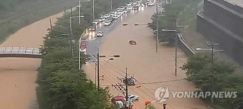 (부산=연합뉴스) 부산지역에 호우경보가 내려진 11일 오전 부산 강서구 지하과학산단로 일대 도로가 인근 하천이 범람해 차량이 통제되고 있다. 2017.9.11  [엘리시아 아파트 입주민 까페 캡처=연합뉴스]       photo@yna.co.kr