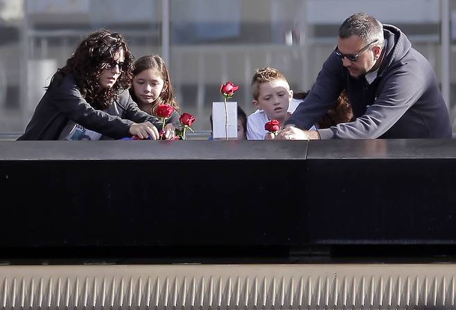 가족들이 11일(현지시간) 미국 뉴욕 그라운드 제로에서 16년 전 테러 희생자들을 추모하고 있다.[UPI=연합뉴스]