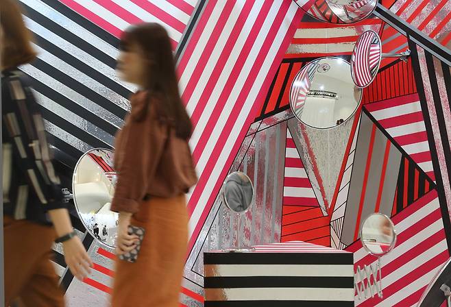 화장실에 있는 거울을 이용한 설치작품 앞으로 관람객이 지나가고 있다. 신인섭 기자