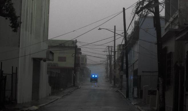 어둠에 휩싸인 도시 - 20일(현지 시각) 허리케인 마리아가 휩쓸고 지나간 푸에르토리코 도심의 모습이다. 건물 불빛이 모두 꺼져 한 자동차 헤드라이트만 빛나고 있다. 푸에르토리코는 이날 마리아의 영향으로 전 지역에 전력 공급이 완전히 끊겼다. /AFP 연합뉴스