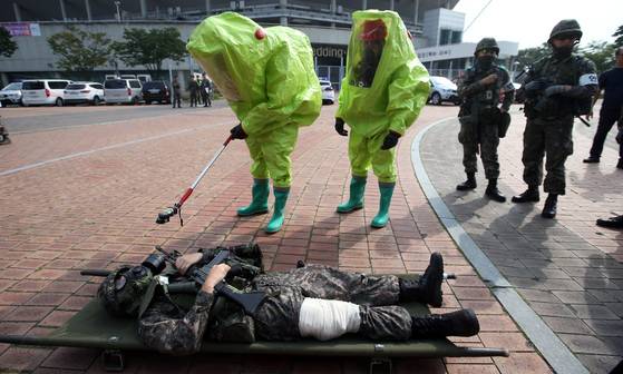 훈련에 참가한 소방대원들이 후송된 화학탄 피해 환자의 방사능 오염여부를 검사하고 있다. 박종근 기자
