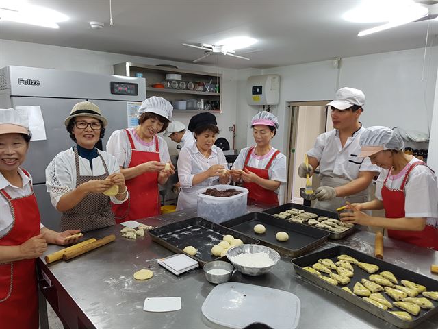 전주빵카페 직원들이 빵을 만들고 있다. 오른쪽 세 번째가 최고령자인 김차남(77)씨다. SK이노베이션 제공