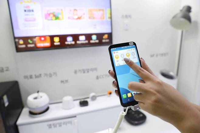 LG 유플러스 전시 관계자가 홈 IOT 서비스를 시연하고 있다. 모바일을 이용해 가전제품을 켜고 끌수 있으며, 실시간 정보파악이 가능하다. 우상조 기자