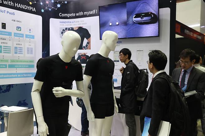 전시장을 찾은 시민들이 마네킹의 의상 가슴부위에 부착된 IOT 제품을 살펴보고 있다. 체온이나 심박수등의 신체 정보를 확인할 수 있다. 우상조 기자