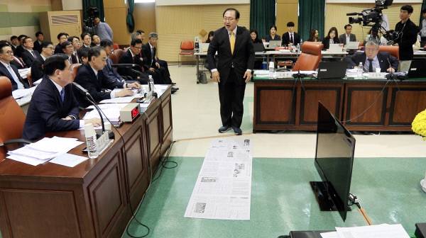 정의당 노회찬 의원이 19일 서울 종로구 감사원에서 열린 국회 법제사법위원회의 감사원 국정감사에서 “일반 재소자 1인당 가용면적은 1.06㎡(약 0.3평)로 일간신문 2장 반밖에 안 되는 면적”이라며 직접 눕기 위해 신문지를 깔고 있다. 노회찬 의원실 제공