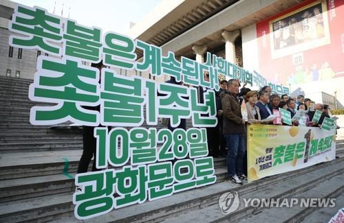 (서울=연합뉴스) 임헌정 기자 = '박근혜정권퇴진 비상국민행동(퇴진행동)' 참가단위 관계자들이 23일 오후 서울 종로구 세종문화회관 계단에서 '촛불은 계속된다'를 주제로 촛불 1주년 선포 기자회견을 하고 있다. 퇴진행동은 촛불 1주년 전날이자 이번 주 토요일인 28일 '적폐청산''사회대개혁' 등을 요구하는 1주년 촛불집회를 개최한다. 2017.10.23  kane@yna.co.kr  (끝)
