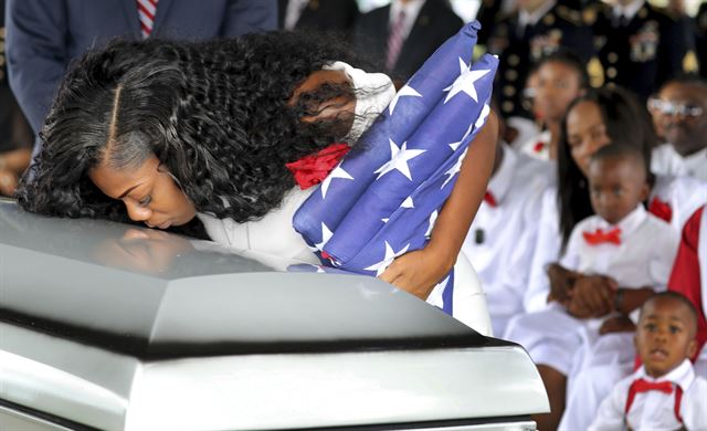 21일 미국 플로리다주에서 치러진 라 데이비드 존슨 병장의 장례식 도중 그의 부인인 마이시아 존슨(왼쪽)이 관에 입맞춤을 하고 있다. AP 연합뉴스