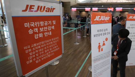 미 교통안전청(TSA) 요청에 따라 미국행 여객기 탑승객에 대한 보안 검색이 강화되기 하루 전인 25일 오후 인천공항 출국장 항공사 카운터 앞에서 제주항공 직원들이 강화된 보안검색 안내 팻말을 설치하고 있다. 한국에서 보안검색 강화는 26일부터 델타항공, 아메리칸항공 등 미국 국적기와 미국령인 괌·사이판 등에 취항하는 국내 저가항공사(LCC)에 적용된다. 아시아나항공과 대한항공은 강화된 보안조치 시행을 유예받았다. [연합뉴스]