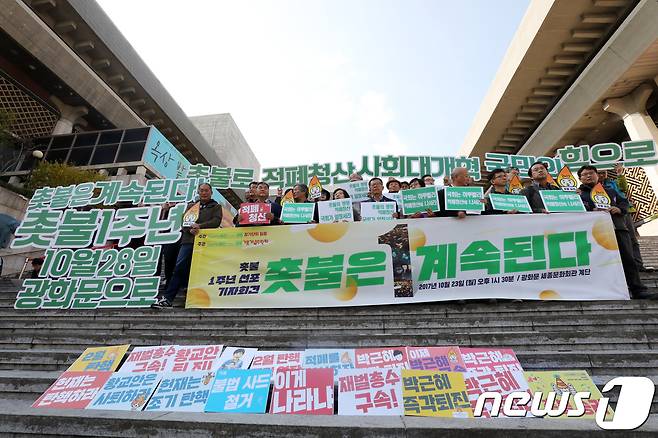 박근혜정권퇴진비상국민행동 회원들이 10월23일 오후 서울 종로구 세종문화회관 계단 앞에서 촛불1주년 선포 기자회견'을 열고 적폐청산과 사회대개혁을 촉구하고 있다.  2017.10.23/뉴스1 © News1 황기선 기자