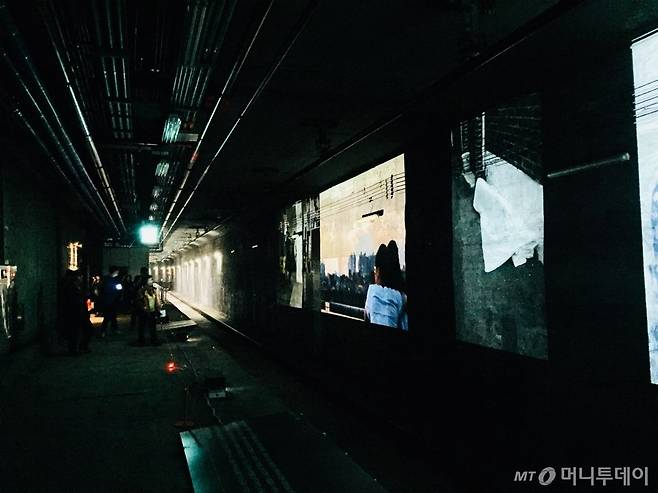 어두운 역 한 쪽엔 사진 작품이 영사되고 있다. /사진=남궁민 기자