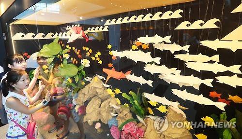 2016년 5월 27일 경기도 과천시 국립과천과학관에서 개막한 특별전 '종이로 표현하는 세상'에서 어린이들이 종이로 만든 물고기들을 관람하고 있다. [연합뉴스 자료 사진]