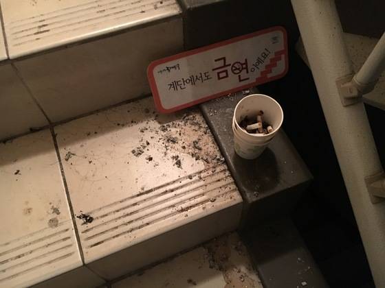 다른 층에는 종이컵에 담배꽁초가 쌓여 있다. 7일 과태료(5만원)가 도입됐지만 별로 도움이 안 될 것이라는 우려가 나온다. [백수진 기자]