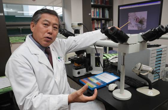 김한겸 교수가 학봉장군과 부인 미라 대장에서 찾은 간디스토마 알의 현미경 사진을 가리키고 있다. 조선시대에도 민물고기를 회로 먹어 간디스토마에 감염됐다는 뜻이다. [김춘식 기자]
