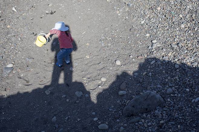 국공립과 민간·가정어린이집의 격차가 커서 아이들은 엄마 자궁에 착상하자마자 국공립에 들어가기 위해 수백 번대의 대기표를 뽑고 줄을 서야 하는 게 현실이다. 지난 추석 제주 해변가에서 흙놀이를 즐기는 두리. 두리 아빠 사진가 점좀빼