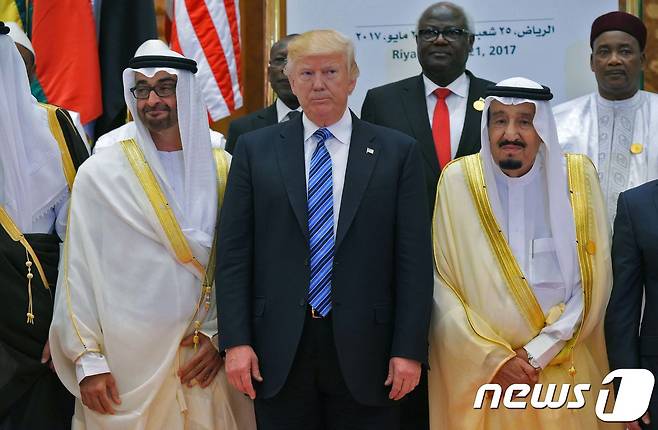 도널드 트럼프 미국 대통령과 살만 이븐 압둘 아지즈 알 사우드 사우디아라비아 국왕, 아부다비의 모하메드 빈 자예드 알 나얀 왕자가 지난 5월  사우디아라비아 리야드 킹 압둘라지즈 컨퍼런스 센터에서 열린 '이슬람 아랍-미국 정상회담’ 중 사진을 찍고 있다. © AFP=뉴스1