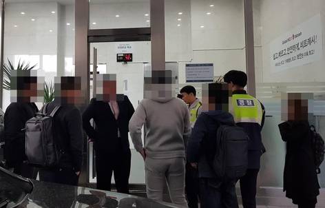 13일 오전 10시 30분 서울 강남구 테헤란로에 위치한 가상화폐 거래소 ‘빗썸’ 본사 1층 문 앞에서 사설 경호업체 직원(왼쪽에서 세번째)과 투자자들이 대치하고 있다. 오른쪽 벽에는 전날 가격이 100만원 이상 급등락한 비트캐시 홍보 현수막이 붙어있다./사진=이민아 기자