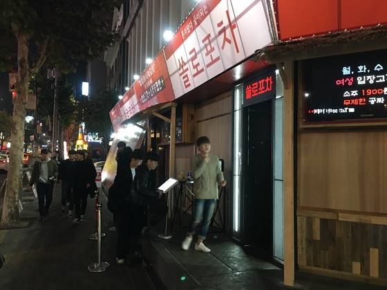 마이크를 들고 주점을 홍보하는 직원. [여성국·하준호 기자]