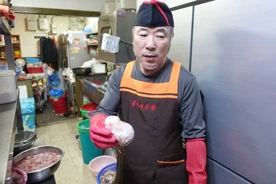 ‘홍박아구탕’의 주인 홍탁근씨가 초벌 삶은 아귀 위를 들어 보이며 ’3㎏이 약간 안 되는 아귀의 위“라고 설명하고 있다.