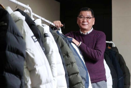 염태순 회장이 20일 서울 둔촌동 신성통상 본사 회장 집무실에서 걸려 있는 평창 롱패딩 옆에서 포즈를 취하고 있다. 김상선 기자