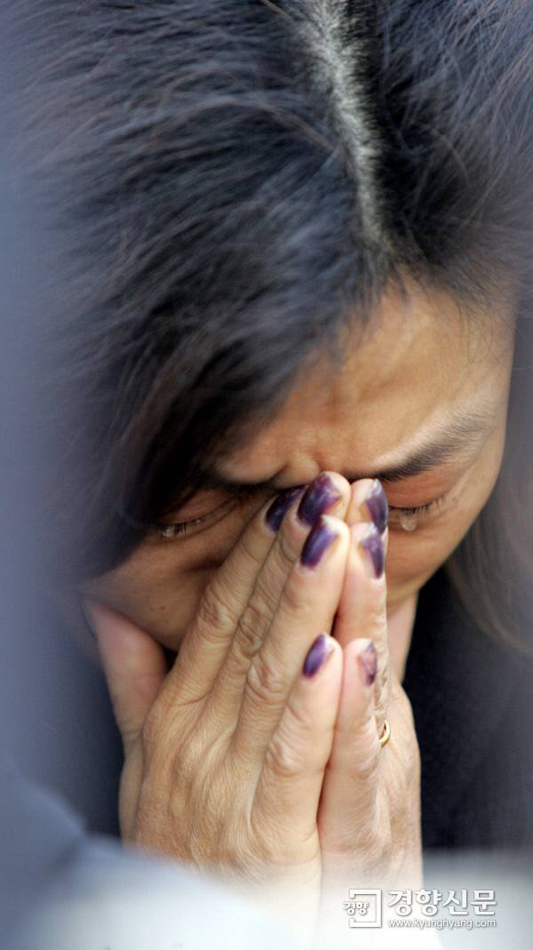 수능시험이 치러진 2004년 11월 17일 학부모들이 서울 풍문여고 교문 밖에서 간절함으로 눈물까지 머금은 채 손모아 기도를 올리고 있다. 경향신문 자료사진