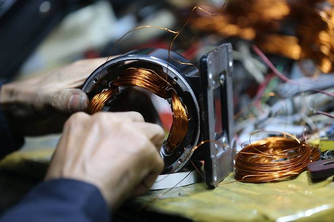 모터 수리 전문인 한 장인이 타버린 모터를 재생하기 위해 코일을 감고 있다. 거친 그의 손이 장인으로 살아온 세월을 말해 준다. 신인섭 기자