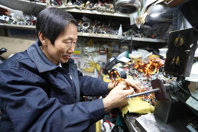 오스타사 운영하는 박희진(66세)씨가 타버린 모터를 재생하기 위해 코일을 감고 있다. 신인섭 기자