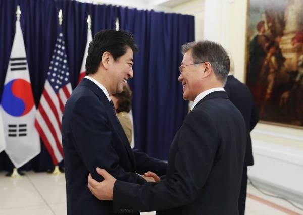 지난 7월 초 독일 함부르크 G20 정상회의에 참석한 문재인 대통령과 아베 신조 일본 총리가 악수를 나누고 있다. [사진=청와대]
