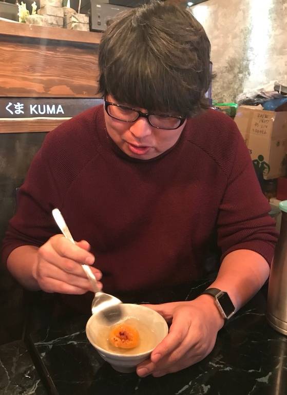 지난 15일 주점에서 우연히 만난 김영하씨가 구운 귤에 설탕을 뿌리고 뜨거운 물을 부어 따뜻한 음료를 만들고 있다.