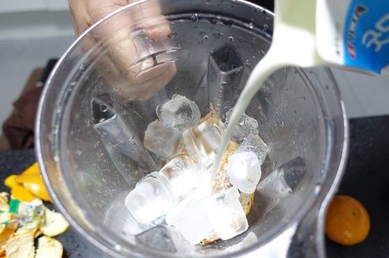 식빵 스무디를 만들려고 블렌더에 식빵·땅콩잼·얼음·설탕을 넣은 다음 우유를 붓고 있다.