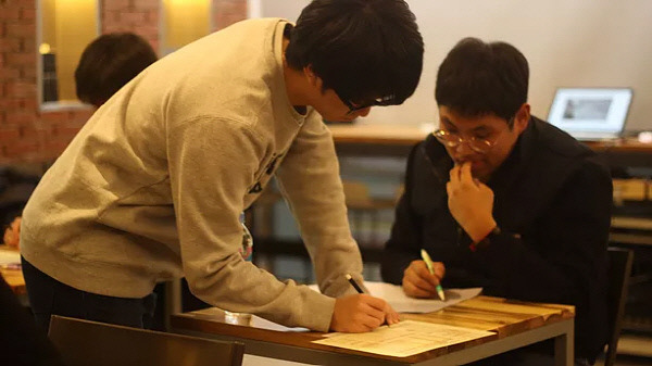 지난 25일 서울 성동구의 한 북카페에서 대학생 등이 모의수능을 치르고 있다. 이날 시험에서 자신이 이미 다니고 있는 대학에 다시 합격할 수 있는 성적을 받은 사람은 단 한 명뿐이었다.|  프로젝트 위기 제공