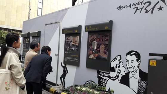 부산 중구 남포동의 '엔터테이너 거리'에 설치돼 있는 극장 소개 패널을 관광객들이 보고 있다.