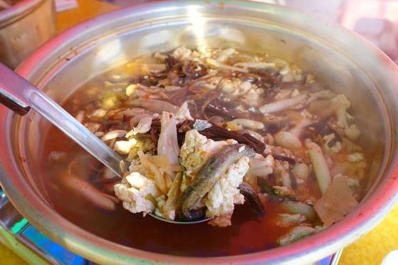 굳히기에 실패해 부스러진 추두부를 쓸어 넣고 끓인 추두부버섯탕. 두부에 꼬리나 머리만 감춘 미꾸라지들이 보인다.