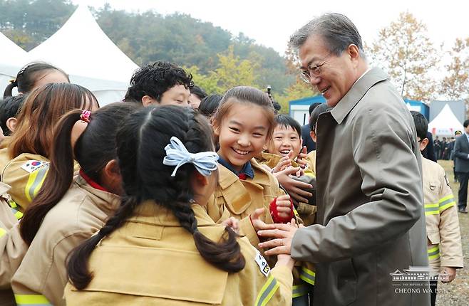 ▲ 문재인 대통령이 11월3일 오전 충남 천안시 중앙소방학교에서 열린 제55주년 소방의날 기념식에서 아산북수초등학교 119소년단 어린이들과 만나고 있다. 사진=청와대