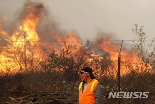LA 북부지역에서 세 번째로 발생, 강풍을 타고 번지는 산불을 5일 (현지시간) 레이크 뷰 테러스의 한 주민이 바라보고 있다./사진=뉴시스
